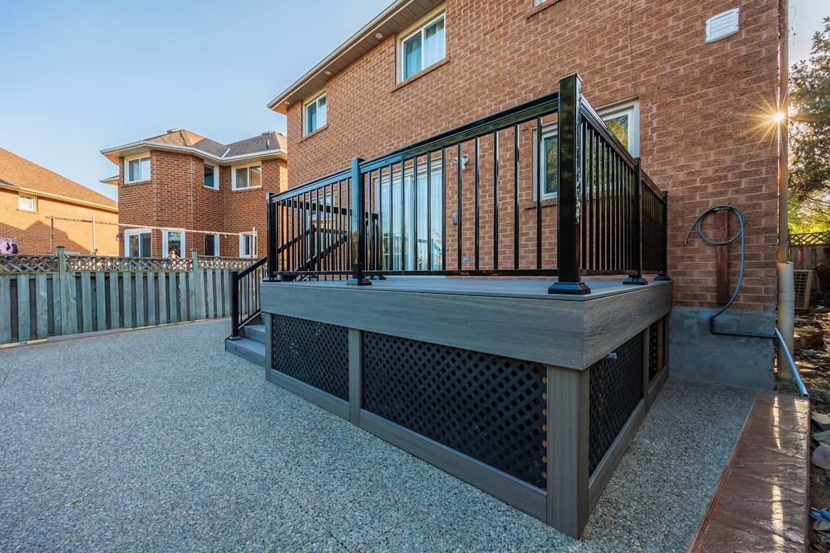 Composite deck with black metal railings on a residential brick home